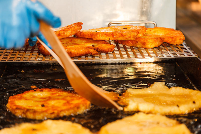 Kartoffelpuffer aus Kloßteig werden frittiert