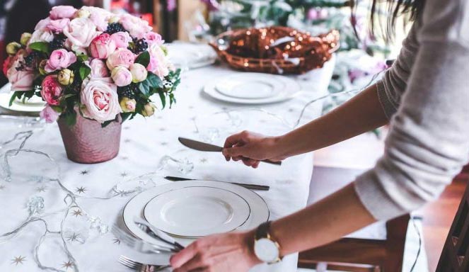 Teller auf Festtagstafel wird angerichtet